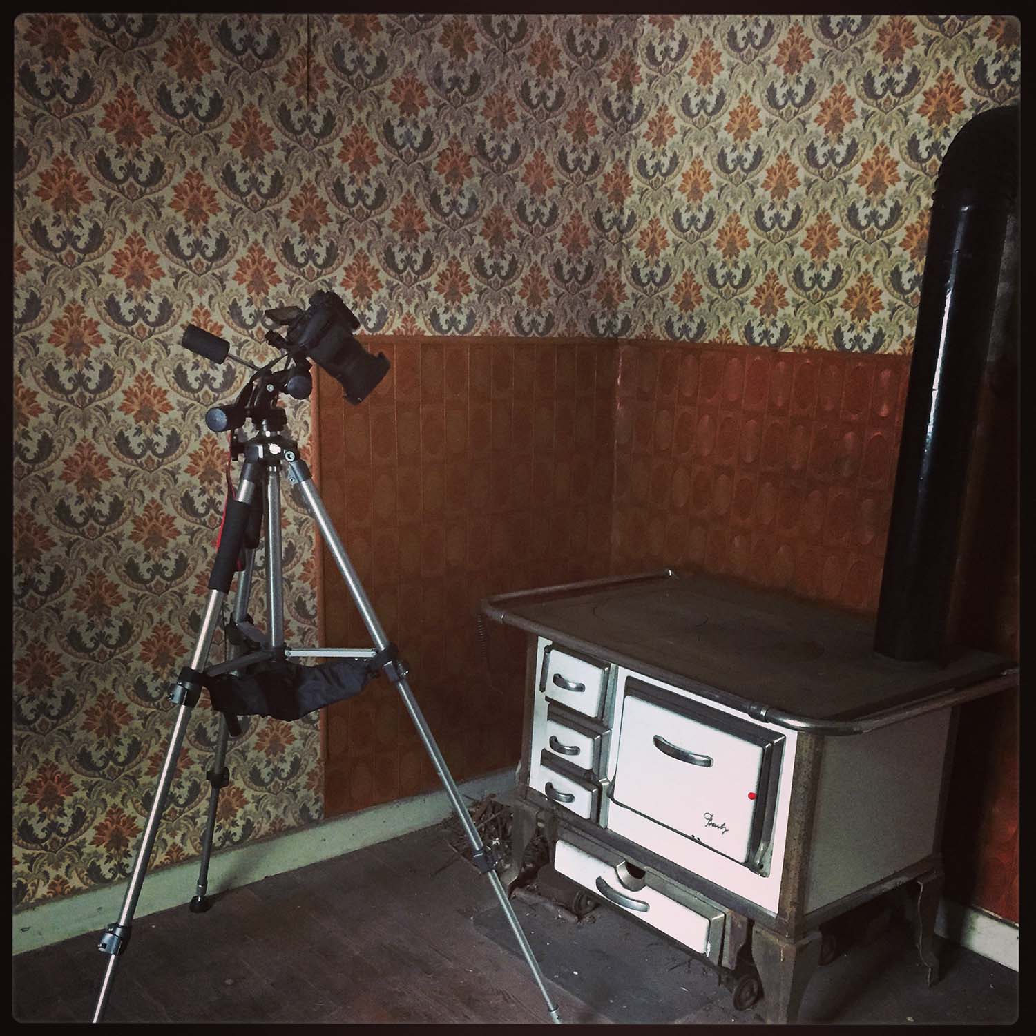 Kamera auf Stativ, gerichtet auf einen sehr alten Küchenherd