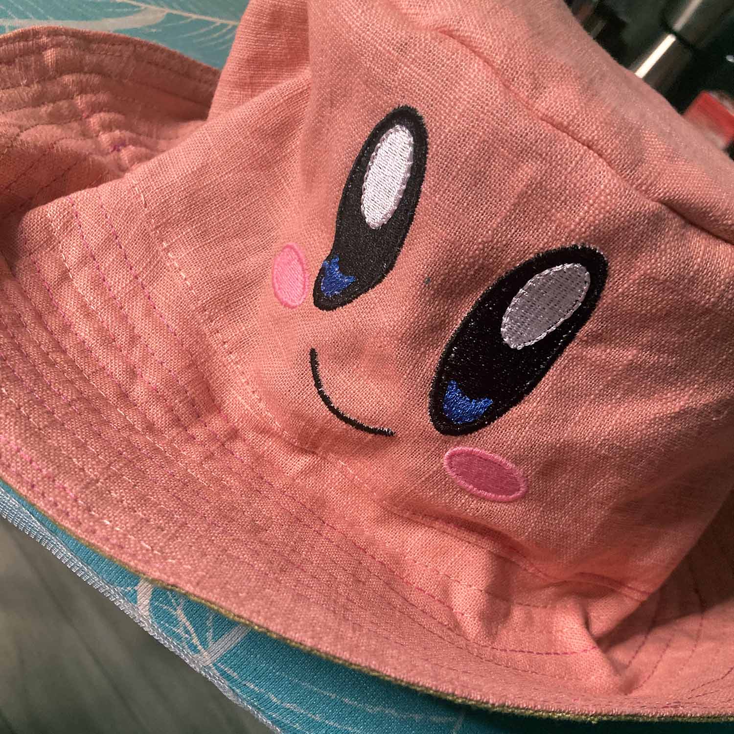 Die rosa Seite mit Stickerei „Kirby-Gesicht“